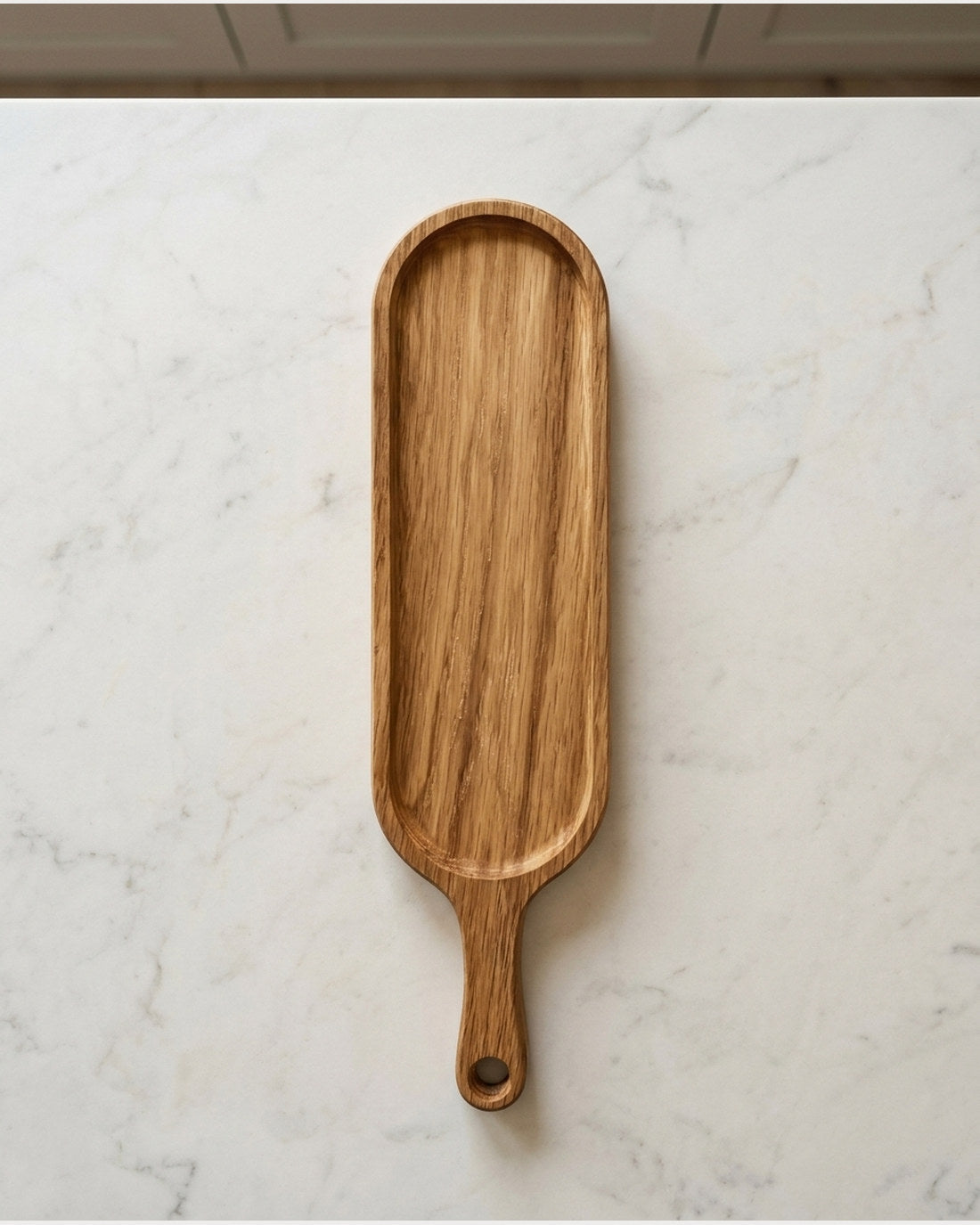 Oak serving board on a pale marble kitchen counter